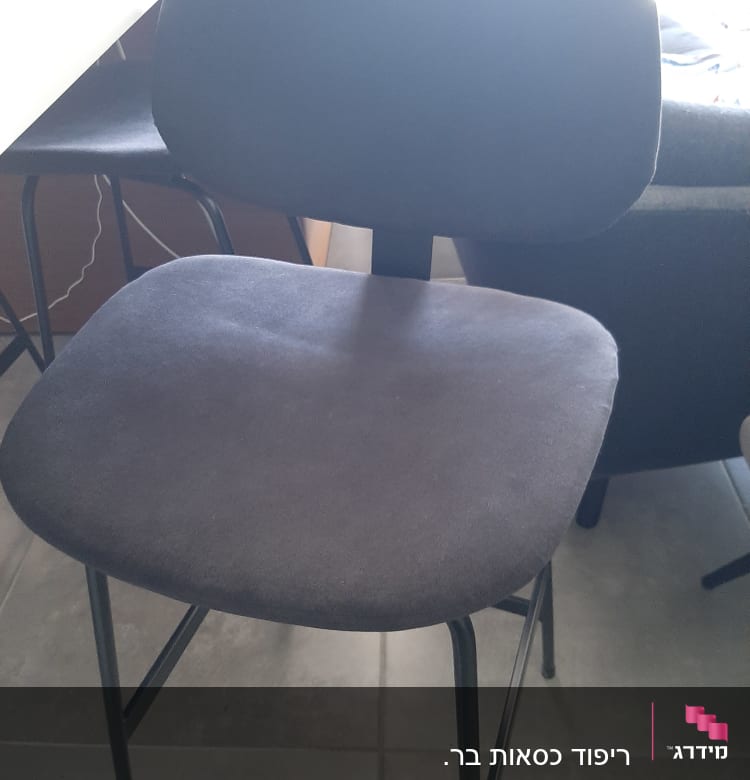 כיסא מרופד עם רגלי מתכת על רצפה אפורה